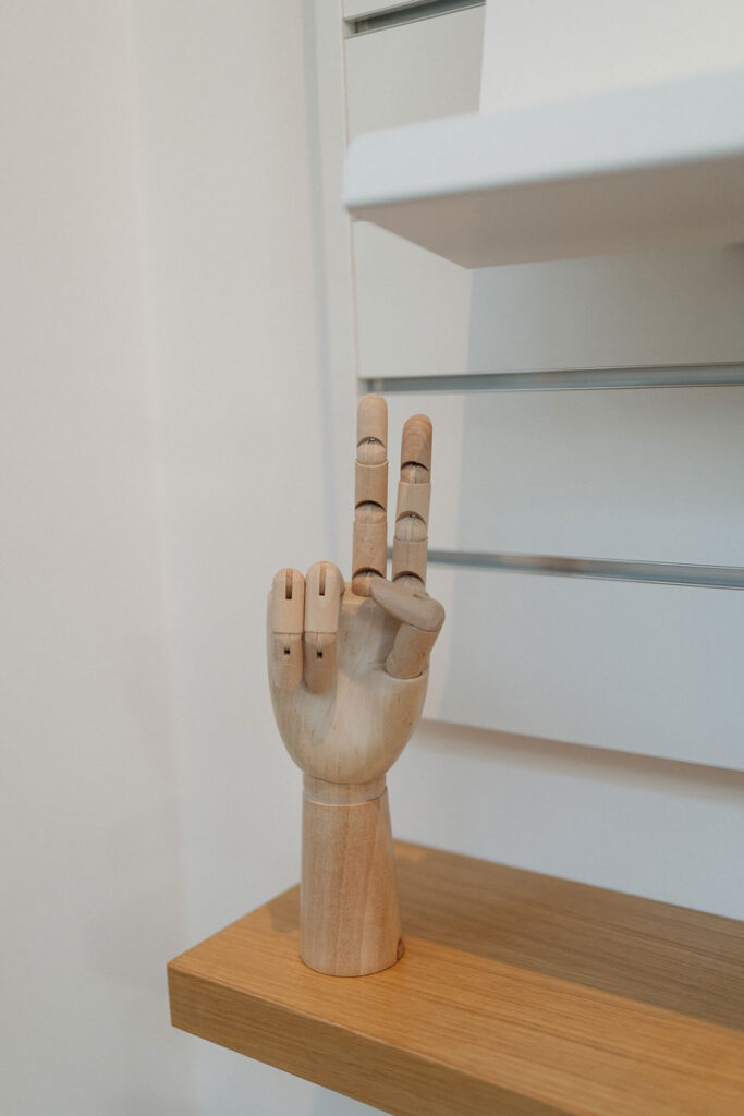 Holzhand, die zu einem Peace-Zeichen geformt ist.